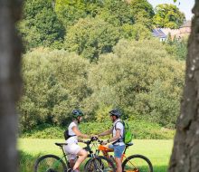 Zwei Radfahrer auf dem Diemelradweg bei Trendelburg, im Hintergrund die Burg Zwei Radfahrer auf dem Diemelradweg bei Trendelburg, im Hintergrund die Burg
