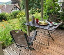 Kleiner Tisch mit zwei St&uuml;hlen drau&szlig;en auf einer Terasse