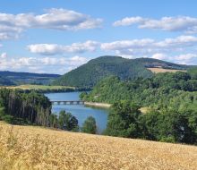Blick &uuml;ber Getreidefeld zum Diemelsee mit Br&uuml;cke nach Stormbruch
