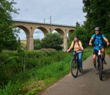 Zwei Radfahrer auf dem Diemelradweg vor dem Viadukt Haueda